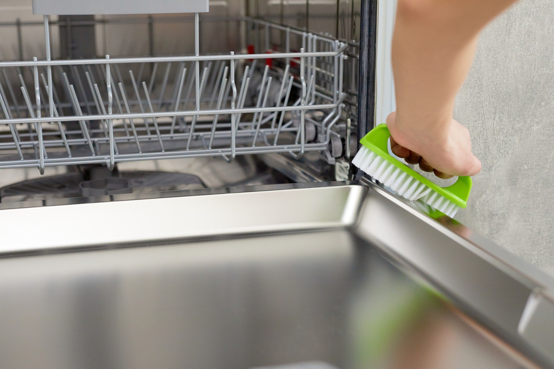 Female hand Clean Dishwasher With Rag or cloth In Kitchen.